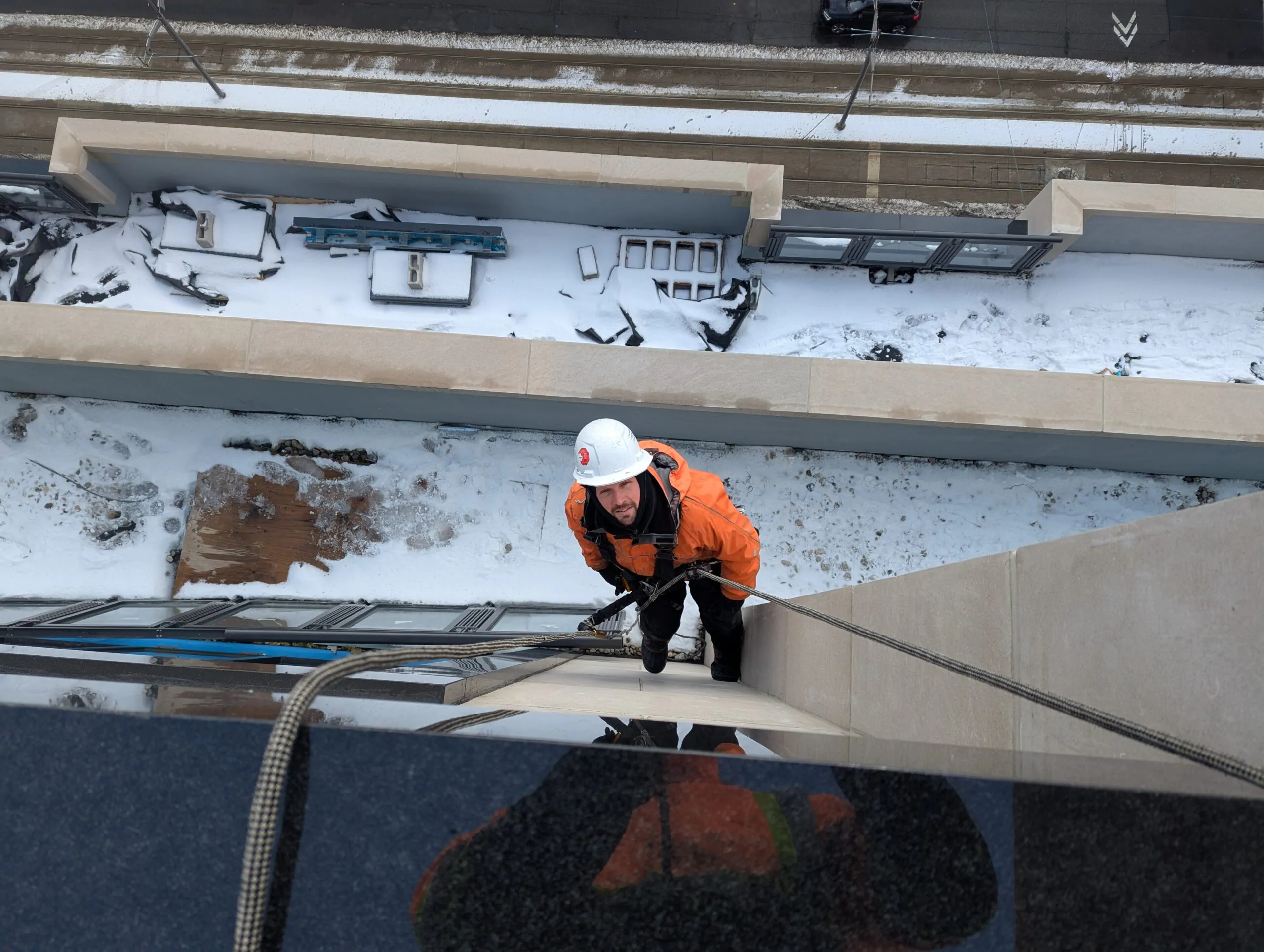 Rope access technician performing masonry repair and restoration on high-rise building in Toronto