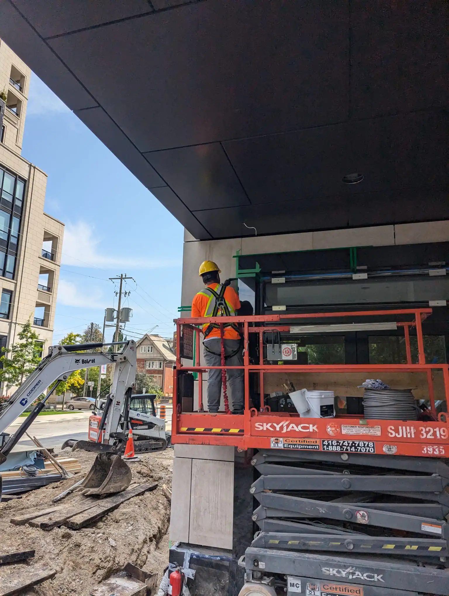 Scissor lift used for vertical access during building restoration project in Toronto by NHC Restoration